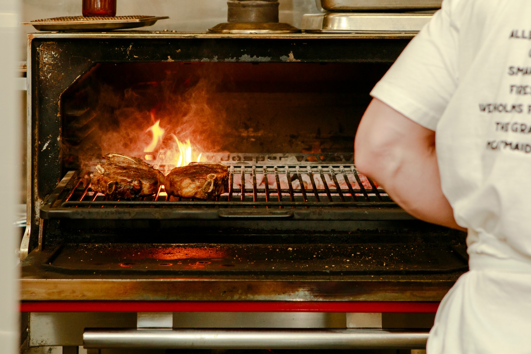 Steaks searing over open flame in the Josper grill at The Grand